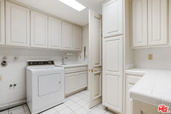 a view of a storage and utility room with dryer and washer