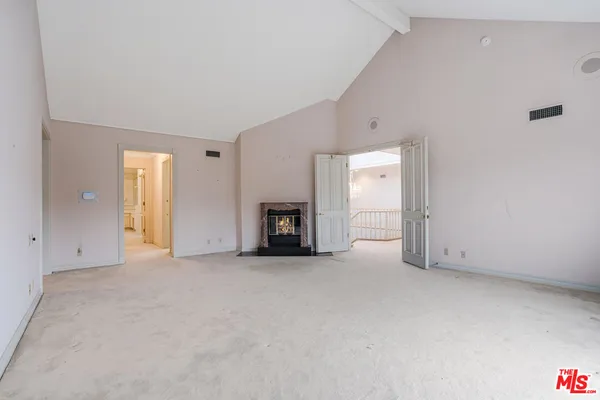 a view of an empty room with a fireplace and a window
