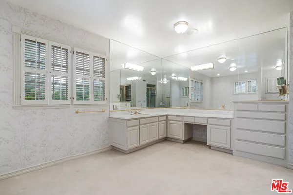 a large bathroom with a large mirror vanity and sink