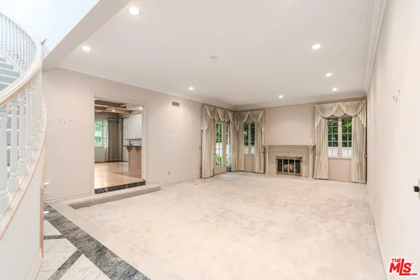 a view of an empty room with fireplace and a window