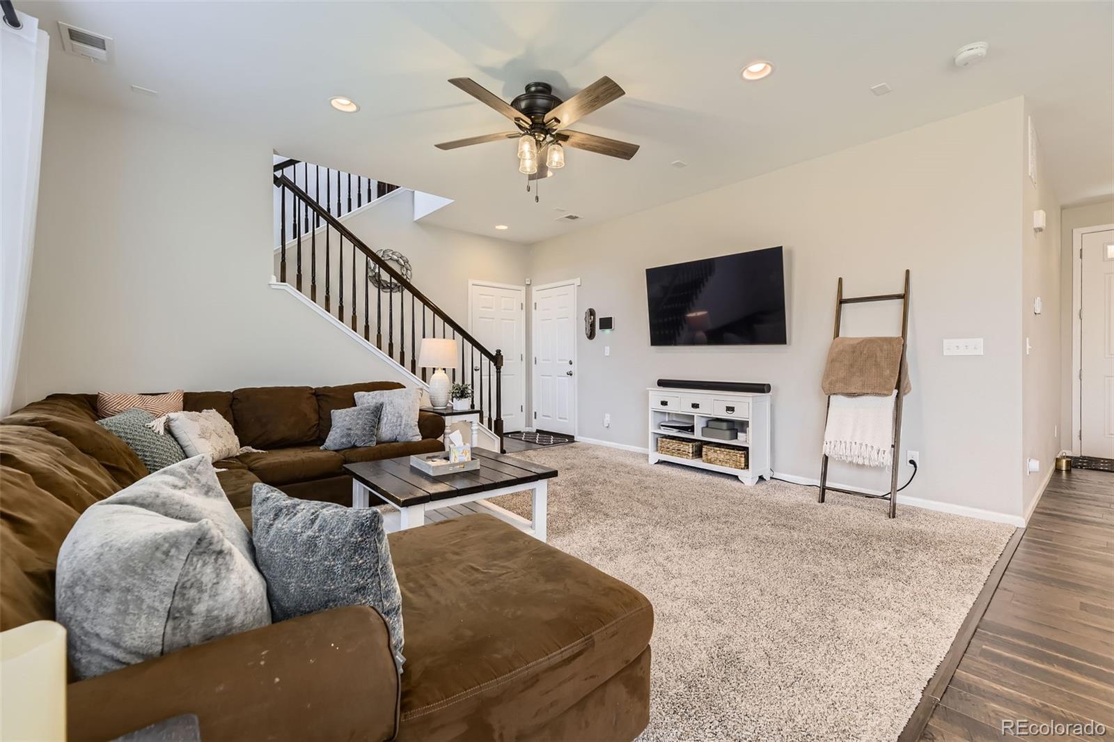 25621 East Cedar Place Aurora, CO 80018 - Photo 11 of 30 a living room with furniture and a flat screen tv with wooden floor