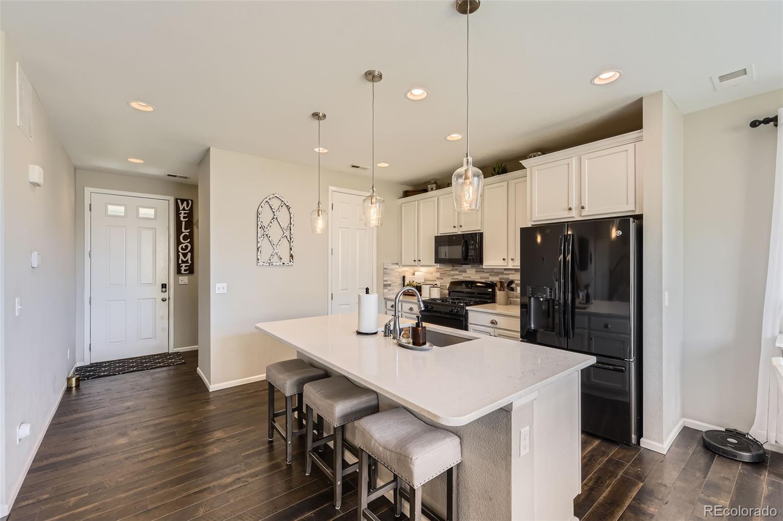 25621 East Cedar Place Aurora, CO 80018 - Photo 7 of 30 a kitchen with stainless steel appliances a refrigerator a sink a stove a microwave oven a sink with wooden floor and cabinets