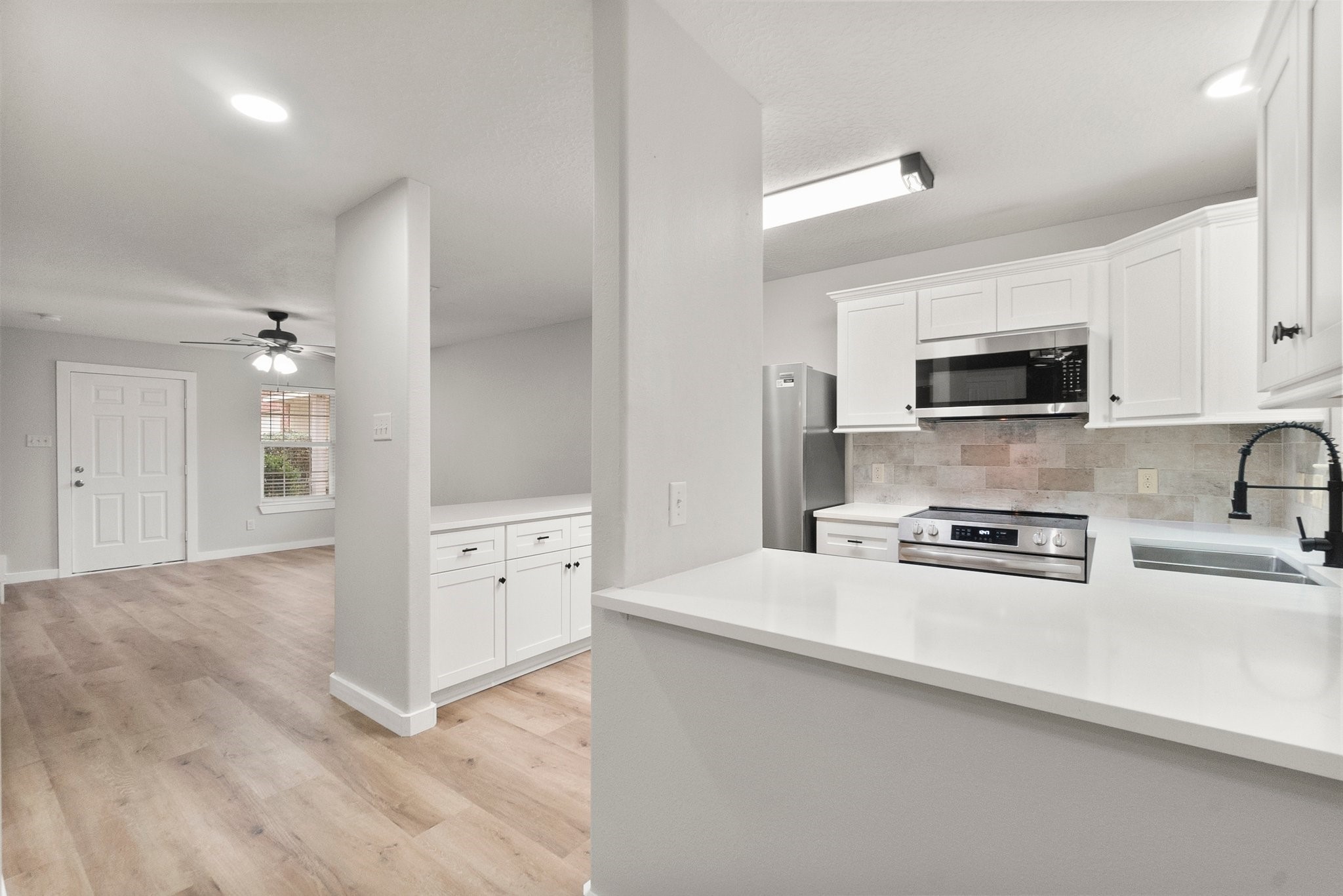 1799 League Line Road, Unit 4 Conroe, TX 77304 - Photo 14 of 34 a kitchen with stainless steel appliances a stove microwave and cabinets