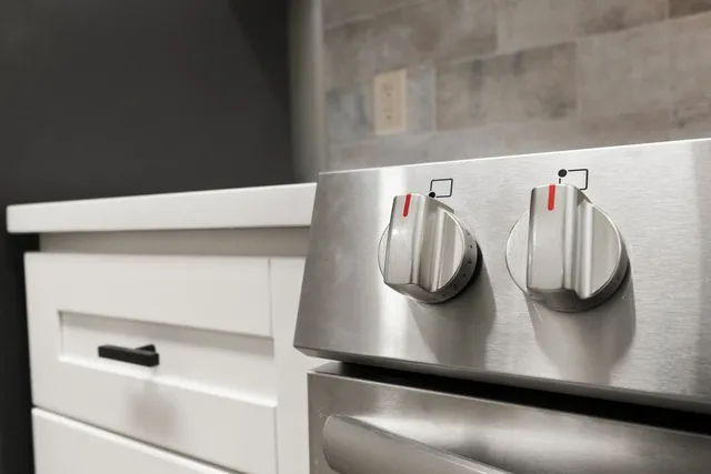 a kitchen with stainless steel appliances granite countertop a refrigerator and a stove top oven