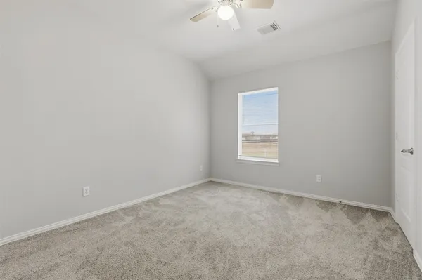 an empty room with a chandelier fan