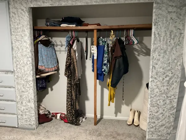 a view of walk in closet with clothes and shoes