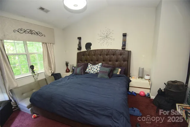 a bed sitting in a bedroom next to a window