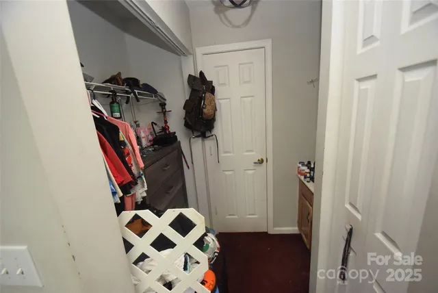 a view of walk in closet with clothes