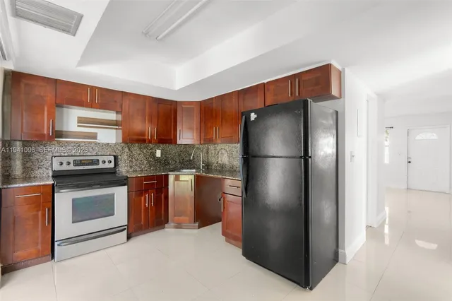 a kitchen with stainless steel appliances granite countertop a refrigerator and a stove