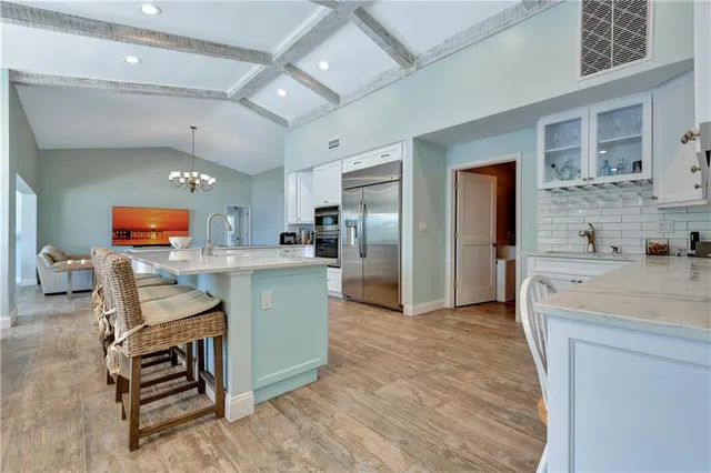 a kitchen with stainless steel appliances kitchen island granite countertop a refrigerator and a stove top oven