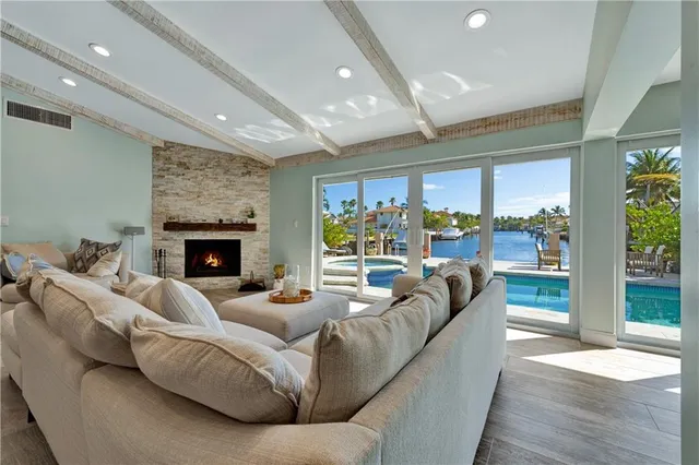 a living room with furniture large windows and a fireplace