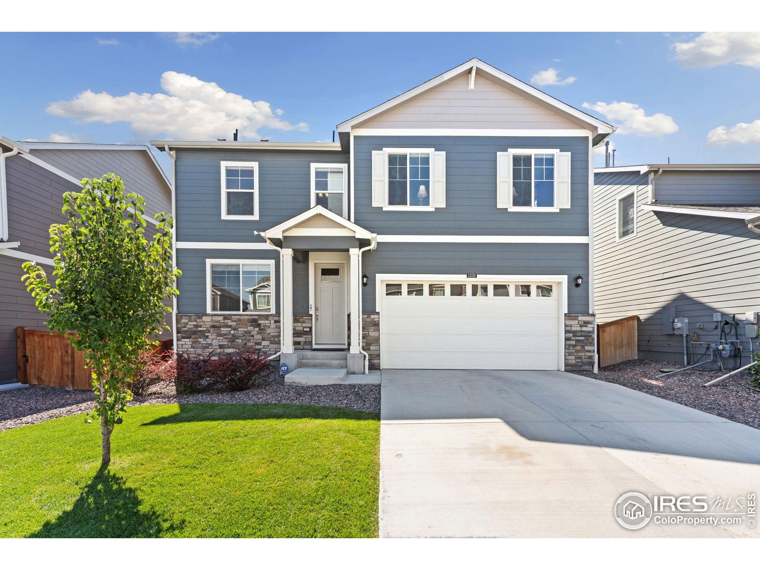 1233 Lily Mountain Road Severance, CO 80550 - Photo 2 of 44 a front view of a house with a yard and garage