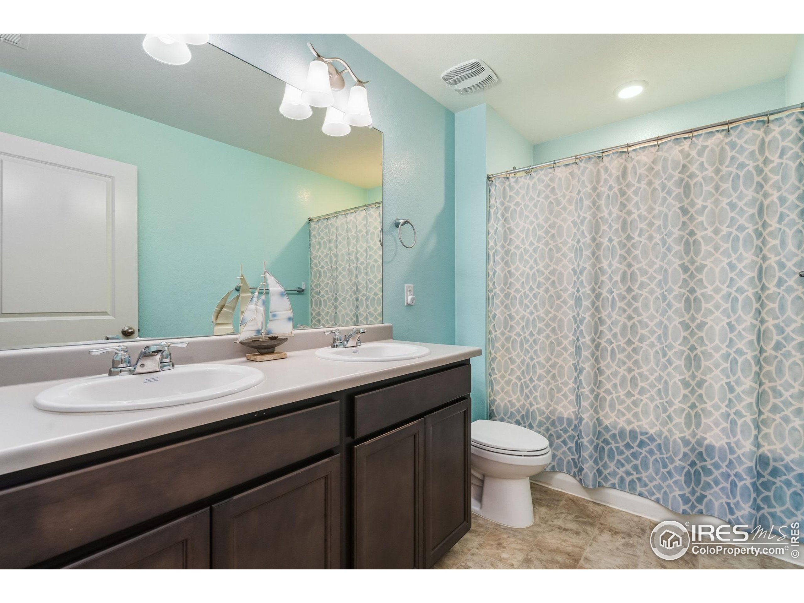 1233 Lily Mountain Road Severance, CO 80550 - Photo 31 of 44 a bathroom with a double vanity sink toilet and a mirror