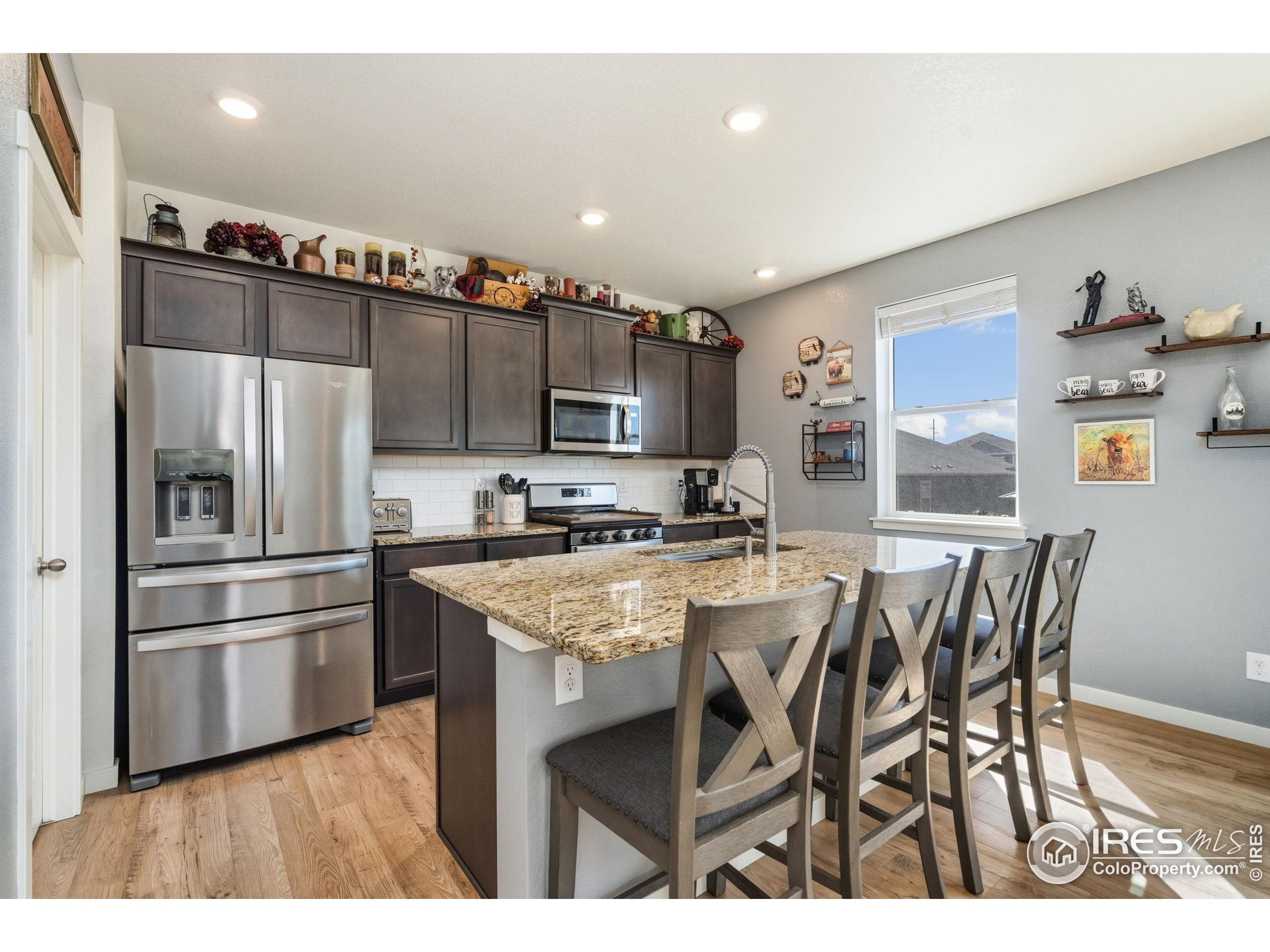 1233 Lily Mountain Road Severance, CO 80550 - Photo 9 of 44 a kitchen with cabinets and stainless steel appliances