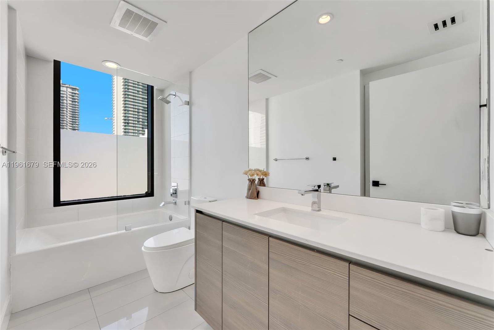 460 Northeast 28th Street, Unit 1601 Miami, FL 33137 - Photo 14 of 41 a bathroom with a double vanity sink mirror and toilet