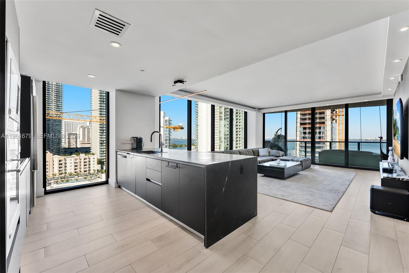 460 Northeast 28th Street, Unit 1601 Miami, FL 33137 - Photo 6 of 41 a large living room with stainless steel appliances granite countertop a couch and cabinets