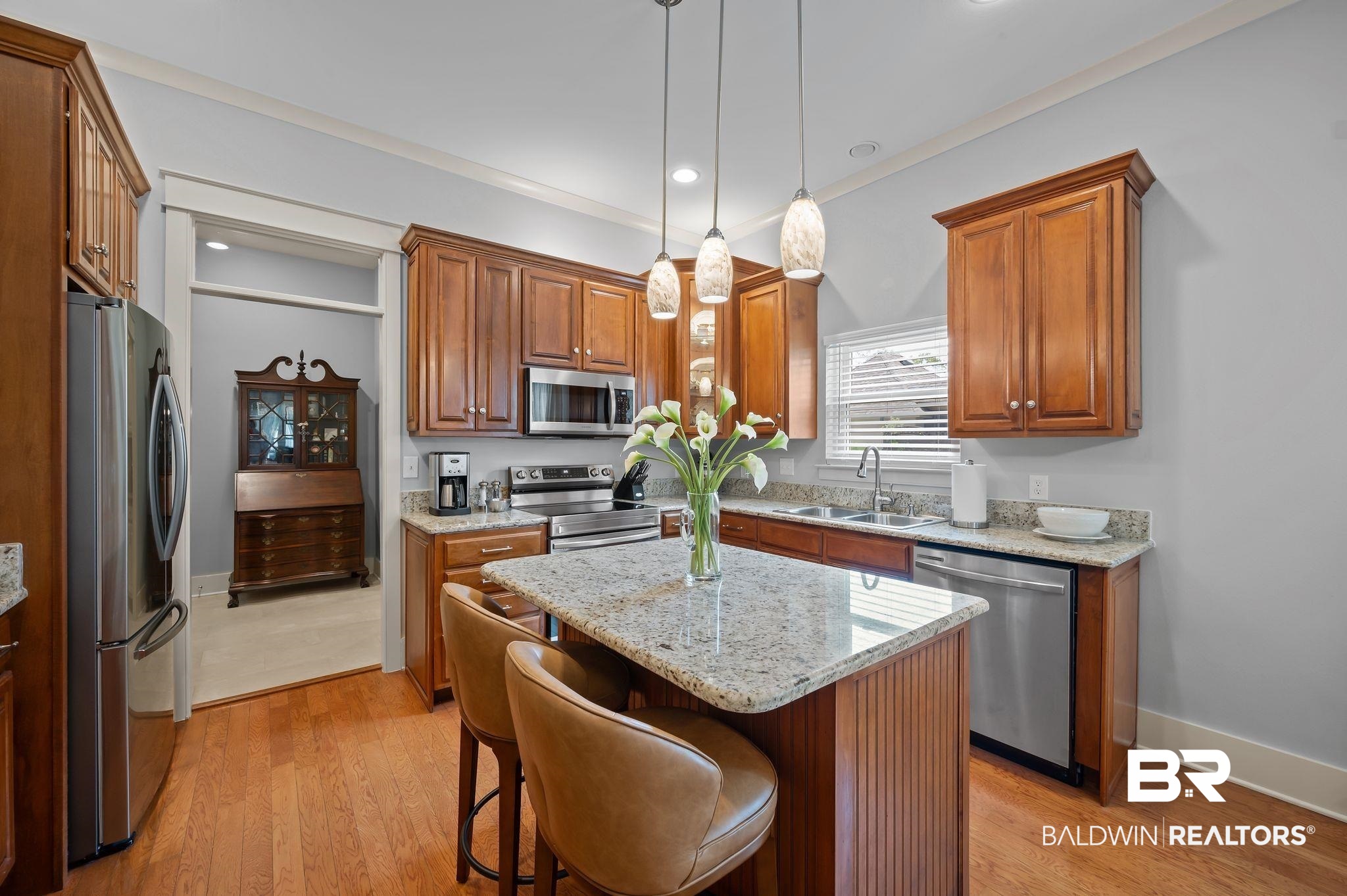 905 Buttercup Lane Foley, AL 36535 - Photo 21 of 47 Kitchen featuring stainless steel appliances, a kitchen island, light wood-style flooring, brown cabinetry, and recessed lighting
