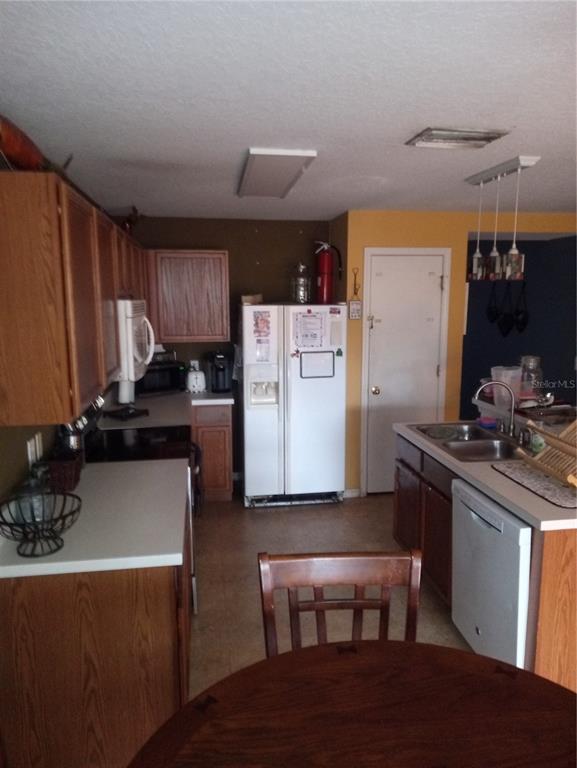 10933 Subtle Trail Drive Riverview, FL 33579 - Photo 5 of 22 a kitchen with stainless steel appliances a stove a sink a refrigerator white cabinets and wooden cabinets