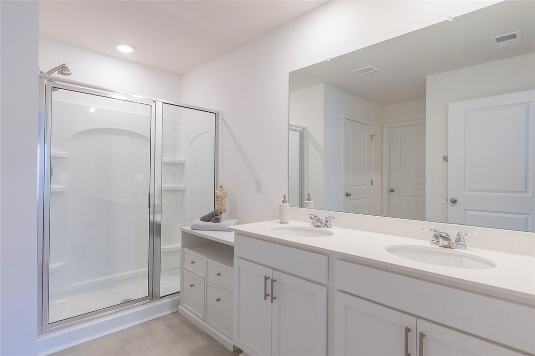 231 Millhone Way Pendleton, SC 29670 - Photo 5 of 32 This spacious bathroom offers a double vanity and a glass-enclosed shower, creating a refreshing daily routine.