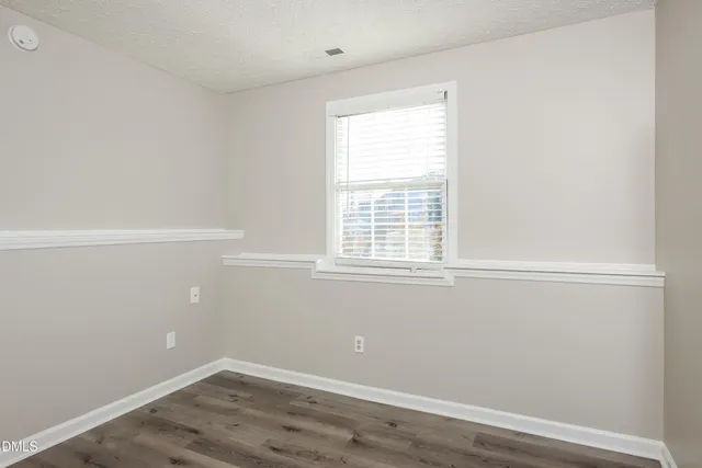 a view of a small space with wooden floor and a window