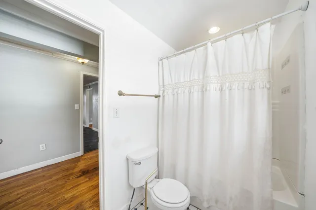 a white toilet sitting next to a shower curtain