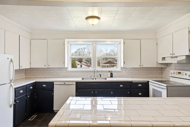 a kitchen with a sink and white cabinets