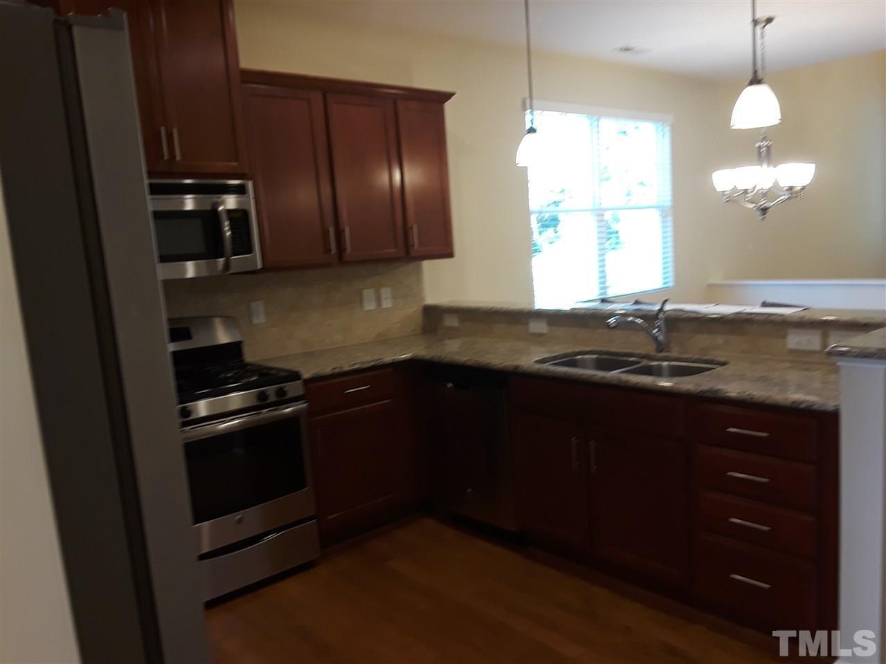 625 Briarcliff Street Apex, NC 27502 - Photo 5 of 18 a kitchen with granite countertop stainless steel appliances and wooden cabinets