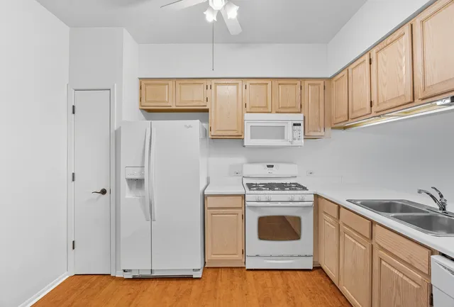 a kitchen with white cabinets and white appliances