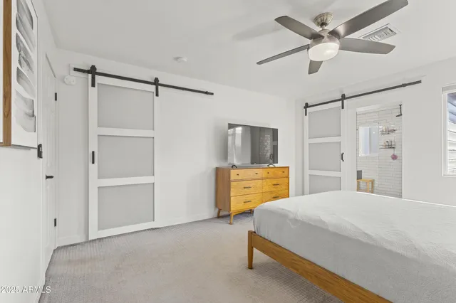 a bedroom with a bed closet and a flat tv screen