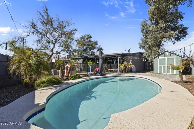 a view of a white house with a swimming pool and sitting area