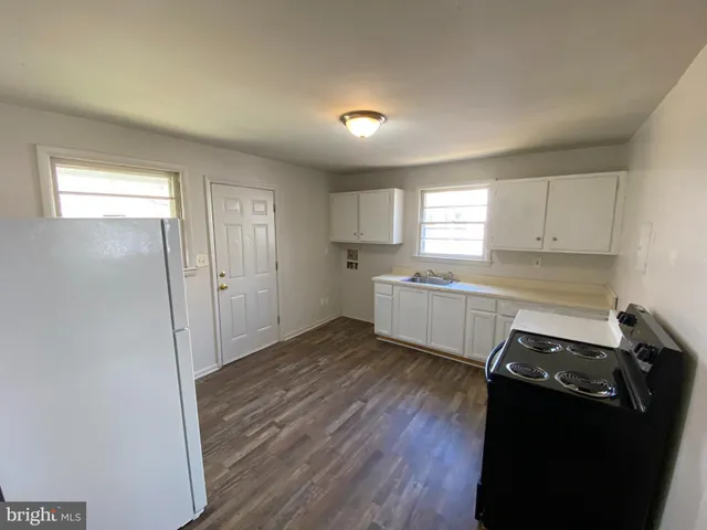 a kitchen with wooden floors and appliances
