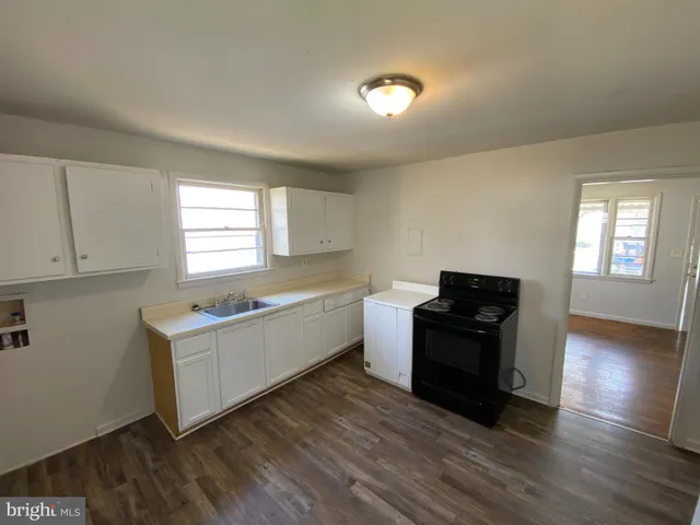 a kitchen with granite countertop a stove top oven and cabinets