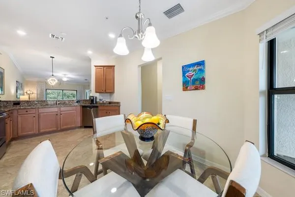 a living room with furniture kitchen view and a chandelier