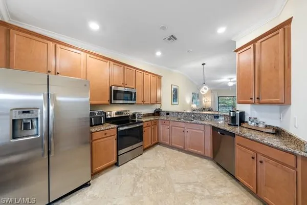 a modern kitchen with stainless steel appliances granite countertop a stove refrigerator sink and microwave