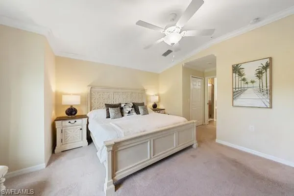 a bedroom with a large bed and ceiling fan