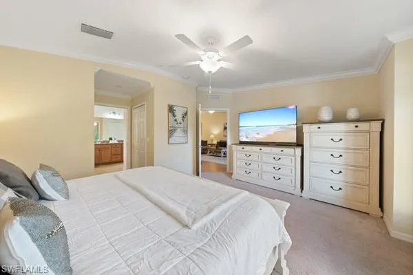 a bedroom with a large bed and a chandelier