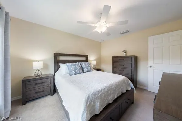 a bedroom with a bed a chandelier and dresser