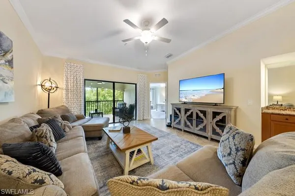 a living room with furniture a large window and a flat screen tv