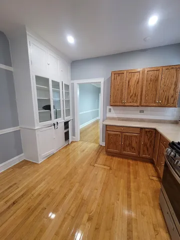 a view of a kitchen with wooden floor and electronic appliances
