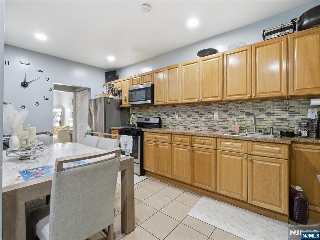 31 Dover Street Paterson, NJ 07501 - Photo 4 of 12 a kitchen with kitchen island granite countertop a sink appliances cabinets and furniture