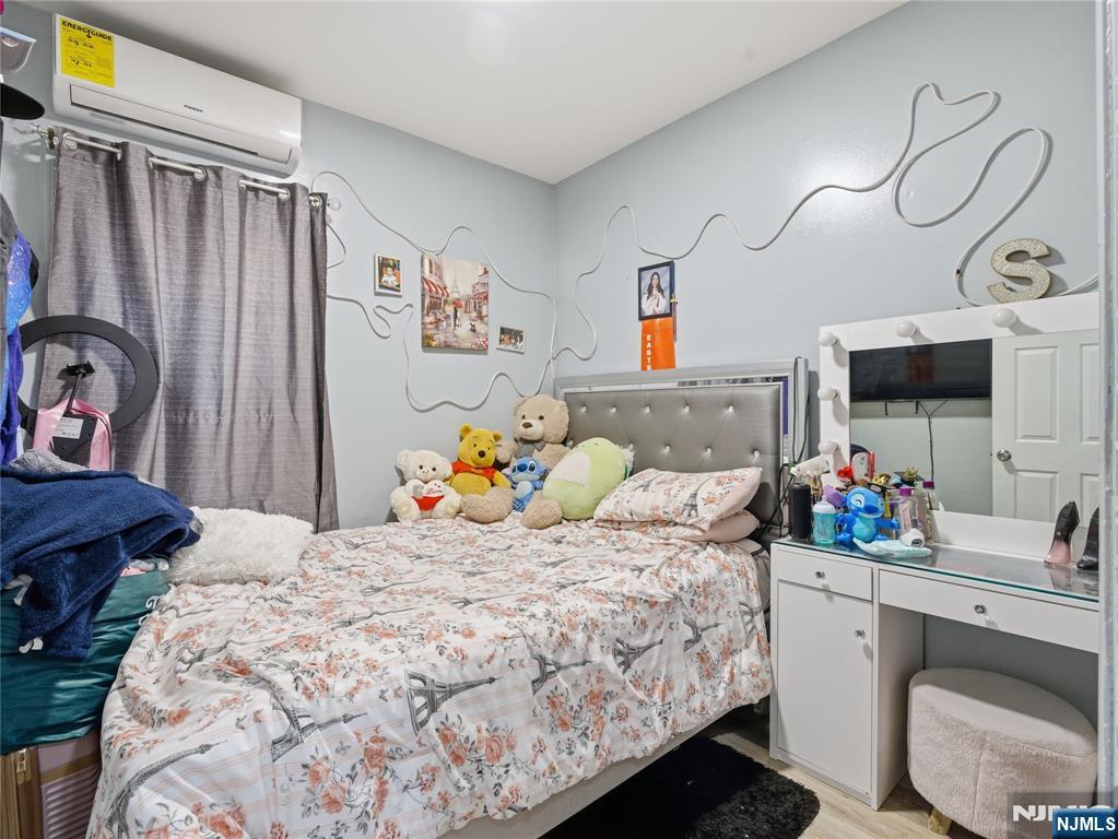 31 Dover Street Paterson, NJ 07501 - Photo 5 of 12 a bedroom with a bed a dresser and a flat screen tv