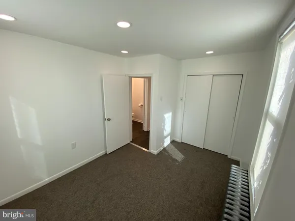 an empty room with closet and wooden floor