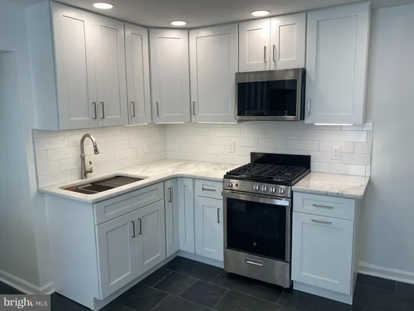 a kitchen with cabinets stainless steel appliances and a sink