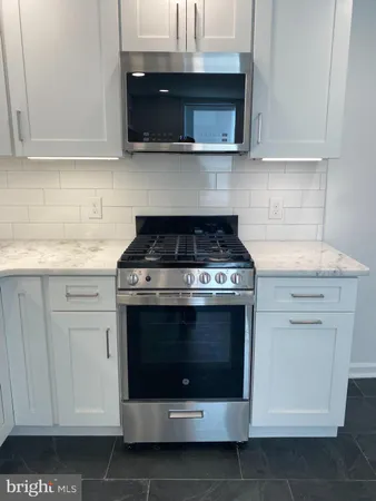 a stove top oven sitting inside of a kitchen