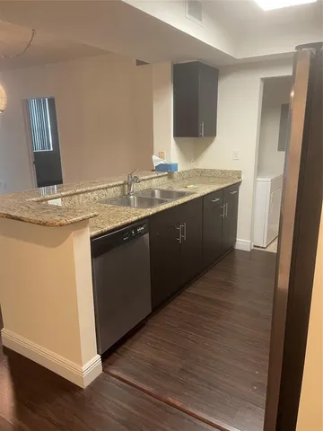 a kitchen with a sink and a wooden floor