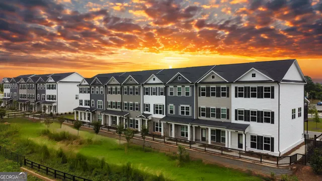 a view of a large white building with a yard