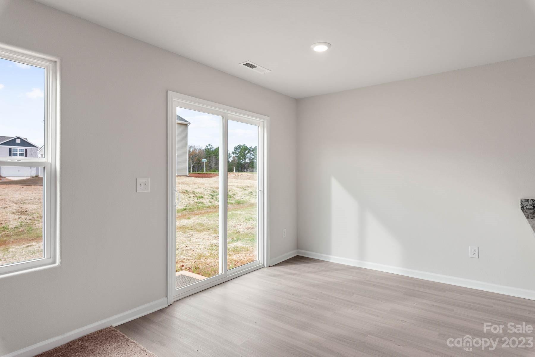 1518 Nia Road Charlotte, NC 28215 - Photo 5 of 14 an empty room with wooden floor and windows