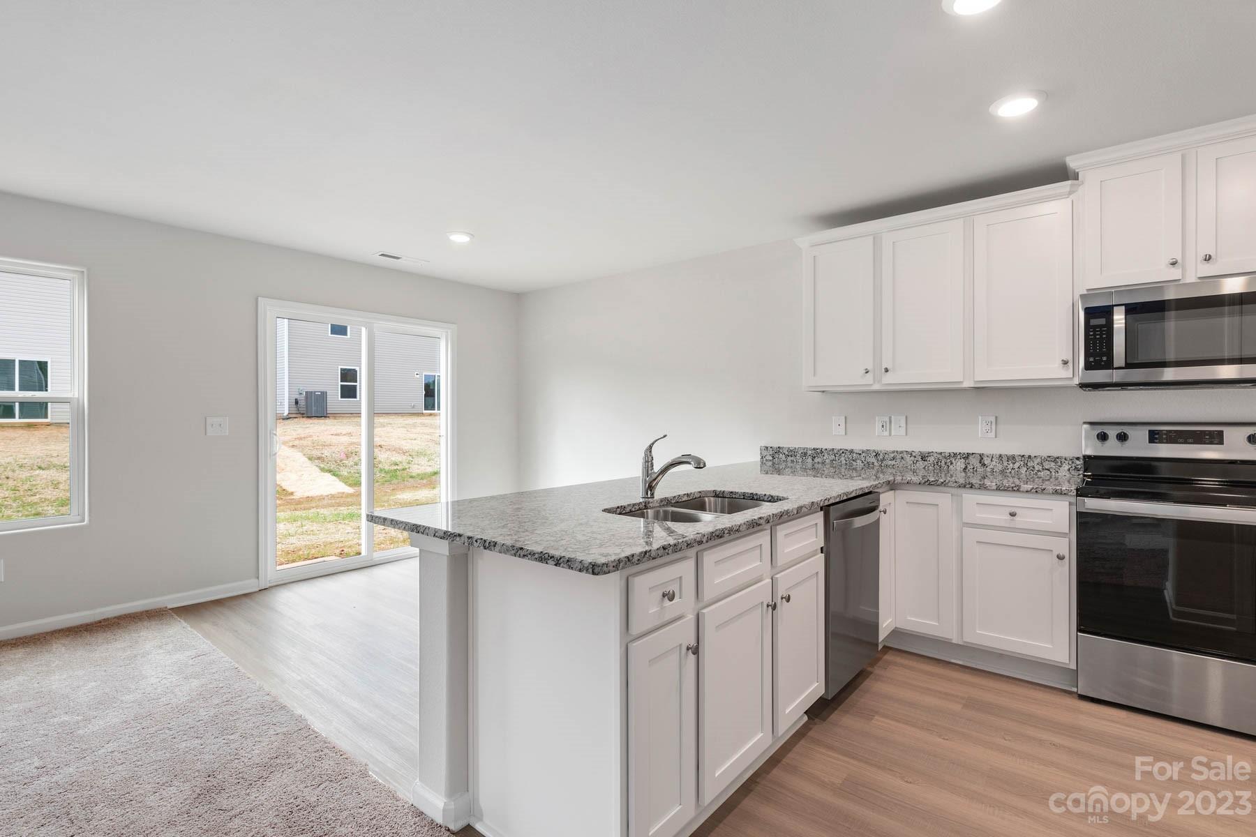 1518 Nia Road Charlotte, NC 28215 - Photo 7 of 14 a kitchen with stainless steel appliances granite countertop a sink stove and cabinets