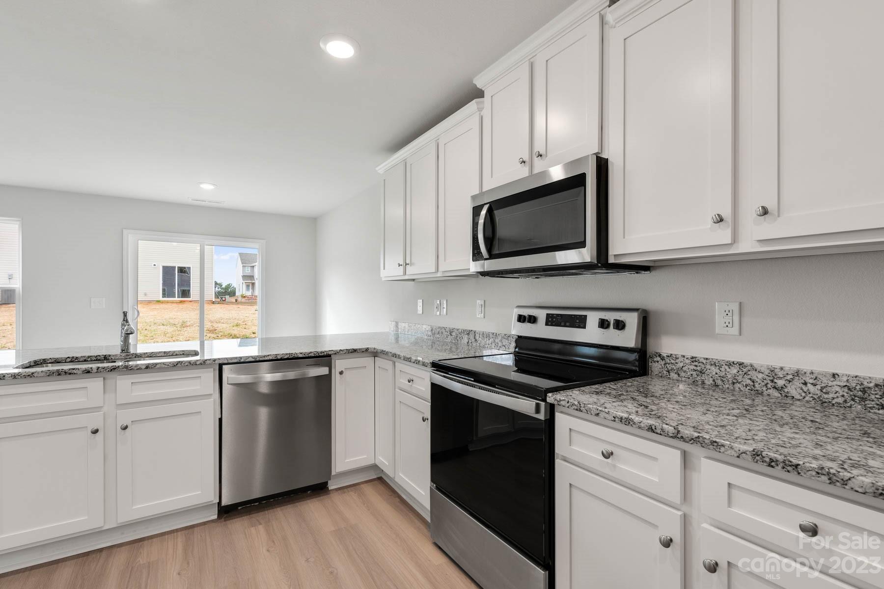 1518 Nia Road Charlotte, NC 28215 - Photo 9 of 14 a kitchen with granite countertop white cabinets and stainless steel appliances