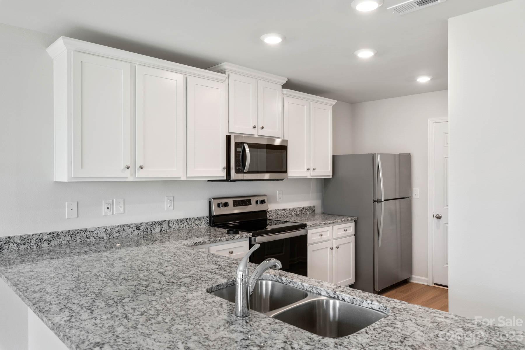 1518 Nia Road Charlotte, NC 28215 - Photo 10 of 14 a kitchen with stainless steel appliances granite countertop a refrigerator a sink a stove a microwave and wooden cabinets